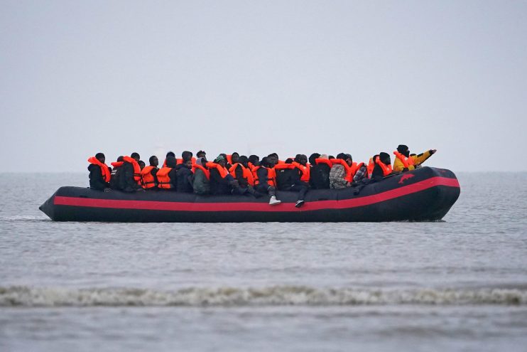 Asylum seekers arriving on a small boat, overseen by Home Office officials, highlighting migration issues in the UK.