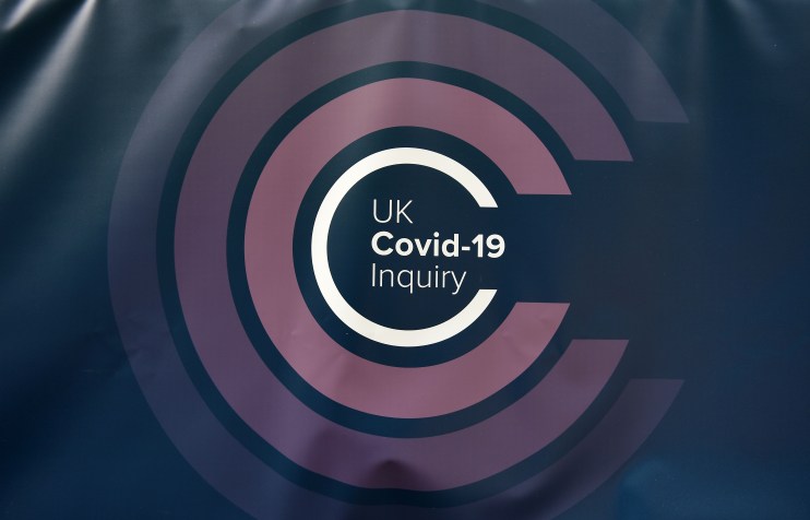 Panel of experts discussing findings during a COVID-19 inquiry meeting, with charts and documents visible on the table