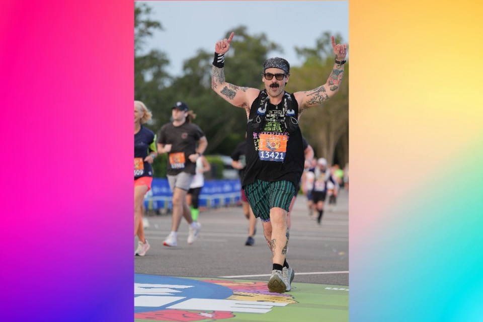 Runners in Disney marathon race surrounded by cheering crowds at the theme park, showcasing vibrant costumes and excitement.