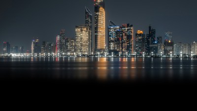 Leon Macapagal captures a bustling urban scene with modern architecture under a clear blue sky, highlighting vibrant city ...