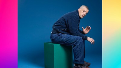 Russell standing against a dynamic swirly background, conveying energy and movement, suitable for a business news setting