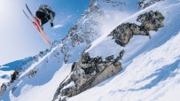 Expert skier carving through fresh powder on a sunny mountain slope, showcasing advanced skiing techniques and winter spor...