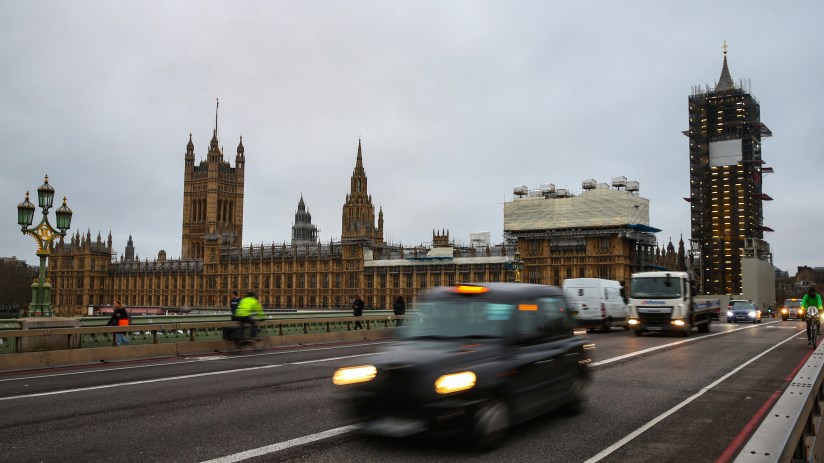 London black taxi navigating busy city streets on a typical day, showcasing urban transportation and iconic British culture