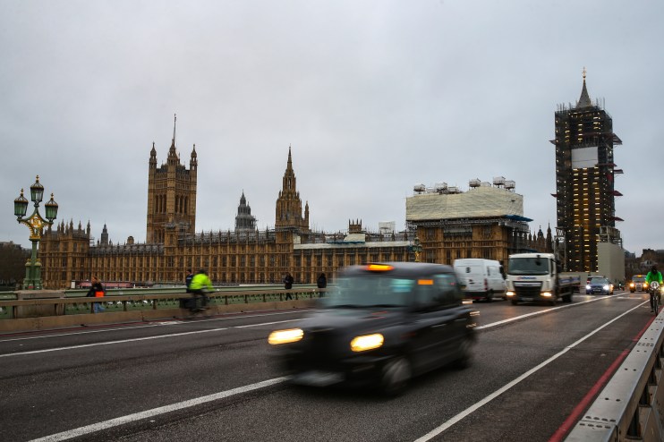 London black taxi navigating busy city streets on a typical day, showcasing urban transportation and iconic British culture