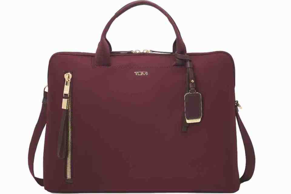 A stylish red Tumi luggage showcased against a modern urban backdrop, highlighting luxury travel essentials.