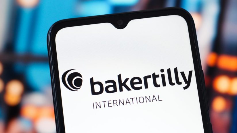 Baker Tilly office exterior with company logo prominently displayed on the building facade, under a clear blue sky.