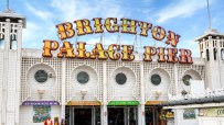 Brighton Palace Pier against a vibrant sunset, bustling with visitors enjoying the iconic seaside attraction and lively at...