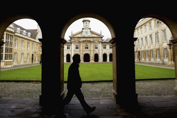 Cambridge University graduates gathered in formal attire during a crisis discussion on campus