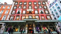 Fortnum store facade with elegant window displays and iconic clock on bustling London street
