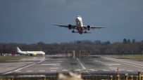 Gatwick Airport terminal bustling with travelers and staff under bright signage and flight information displays