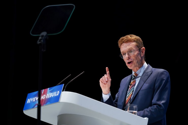 GettyImages 2175467075 shows a diverse group of professionals collaborating in a modern office setting, highlighting teamw...