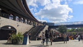 Kings Cross Coal Drops Yard bustling with shoppers and visitors amidst modern architecture and vibrant store displays