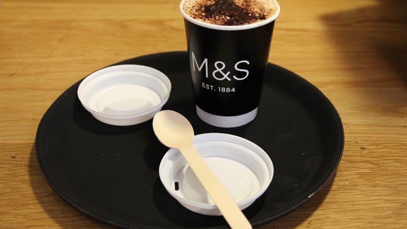 Microsoft coffee mug on a desk with a laptop, symbolizing tech industry trends and workplace culture discussions.