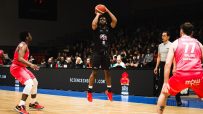 Manchester basketball court with players in action, showcasing teamwork and athleticism, under clear skies during a local ...