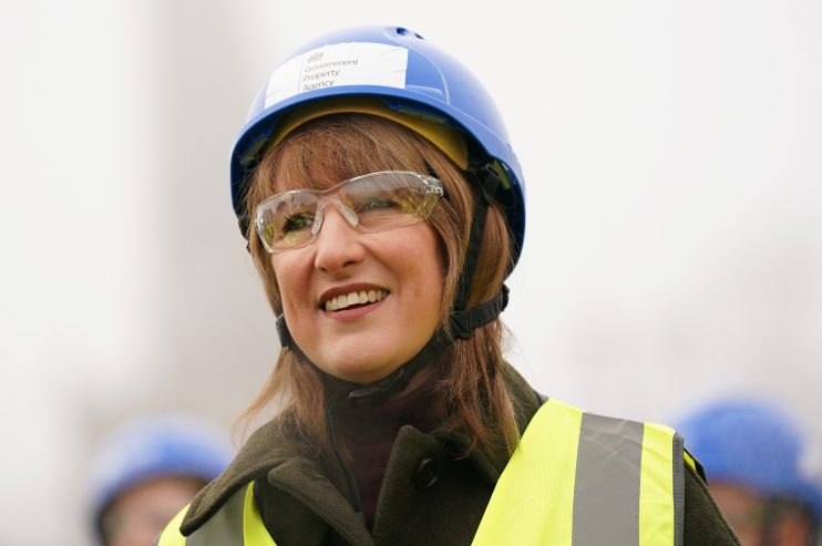 Rachel Reeves wearing a hard hat and high-visibility vest, inspecting construction progress at a building site