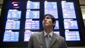 Tokyo Stock Exchange trading floor with digital stock tickers displaying market trends and financial data.