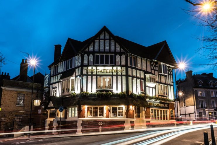 Bustling urban pub scene with diverse patrons enjoying drinks at a stylish bar, showcasing modern city nightlife ambiance.