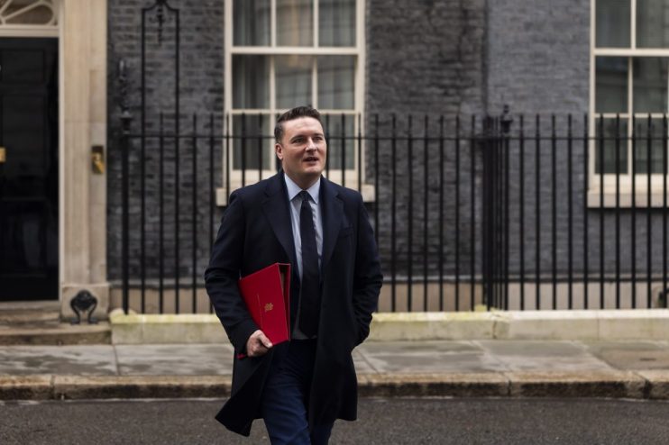 Wes Streeting speaking at a podium during a public event, wearing a suit and tie, addressing key issues in the general cat...