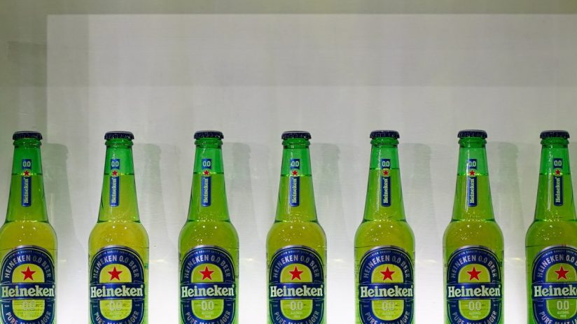 Heineken alcohol-free beer bottle on a table, showcasing its label and branding in a news feature on non-alcoholic beverages