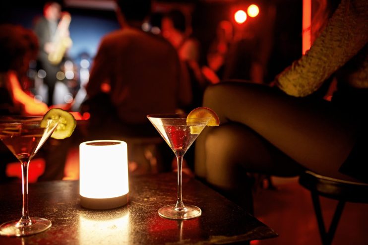 Chic cocktail bar interior with stylish seating, ambient lighting, and an array of colorful drinks on display