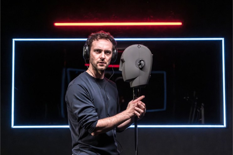 Mysterious spectral figure whispering into human ear, representing eerie communication in technology news context.