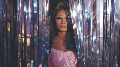 Breaking news event featuring a large crowd gathered in a city square, with banners and diverse participants engaging acti...