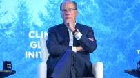 Larry Fink, CEO of BlackRock, speaking at a business conference, wearing a suit and glasses, gesturing with his hands