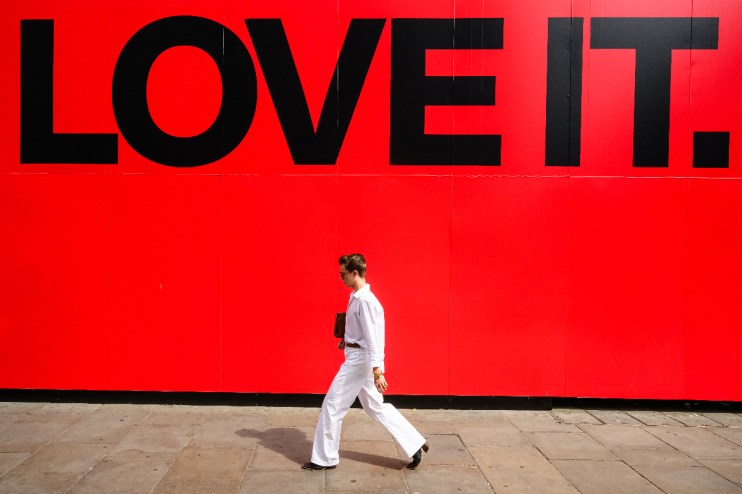 Person walking on a busy city street, surrounded by modern skyscrapers, showcasing urban lifestyle and daily commute.