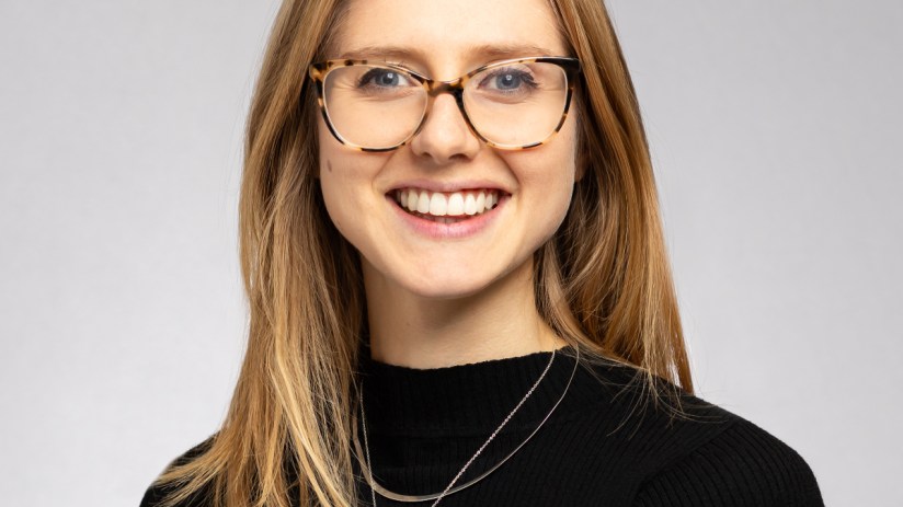 Marianna Hunt discussing financial strategies at a business conference, wearing a professional suit, engaging with the aud...