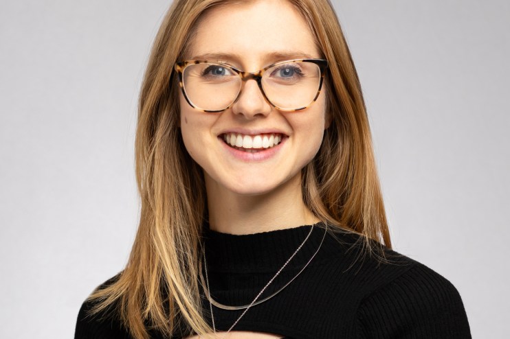 Marianna Hunt discussing financial strategies at a business conference, wearing a professional suit, engaging with the aud...