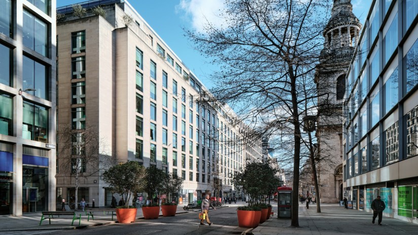 Four businessmen crossing Cheapside road in London during daytime, highlighting urban commuting and professional attire.