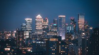Canary Wharf skyline illuminated at night, showcasing Londons financial hub with iconic skyscrapers and vibrant city lights