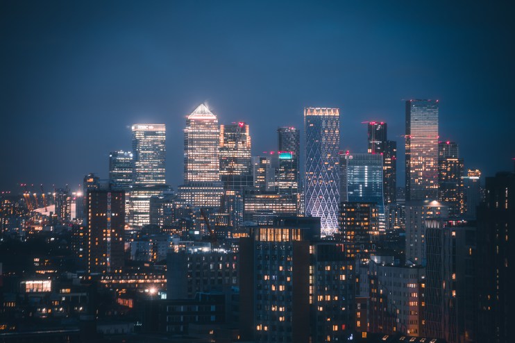 Canary Wharf skyline illuminated at night, showcasing Londons financial hub with iconic skyscrapers and vibrant city lights