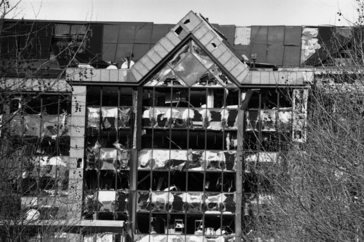 Docklands bomb aftermath showing damaged structures and emergency response teams assessing the scene