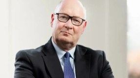 Douglas Flint, prominent business leader, addressing an audience at a corporate event in a formal setting