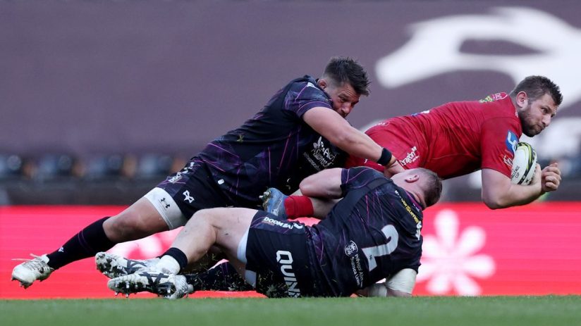 GettyImages 2208853013: Business professionals discussing strategy in an office setting, engaging in lively conversation.