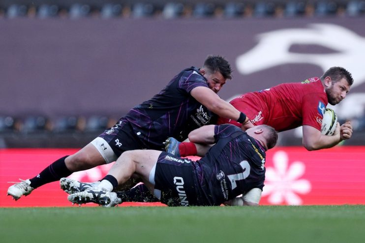 GettyImages 2208853013: Business professionals discussing strategy in an office setting, engaging in lively conversation.