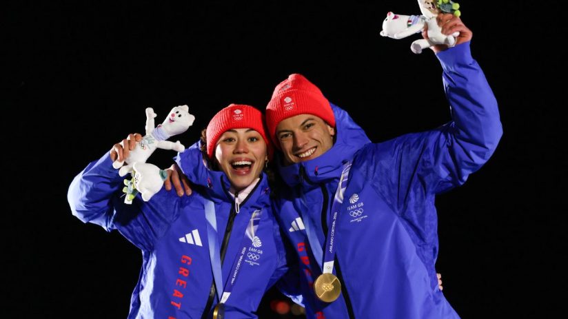 Business professionals discussing strategy in a modern office setting with charts and laptops visible on the table