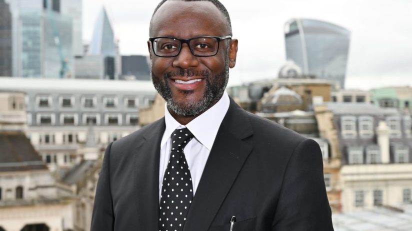 Ian Thomas CBE smiling, wearing a formal suit, possibly at a business event or award ceremony, showcasing professional rec...