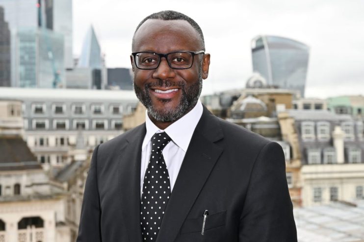 Ian Thomas CBE smiling, wearing a formal suit, possibly at a business event or award ceremony, showcasing professional rec...