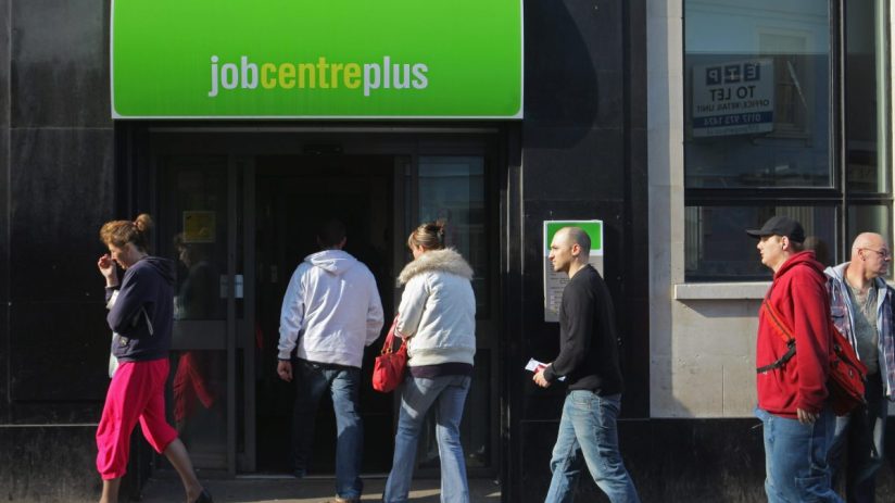 People waiting outside a job centre, highlighting unemployment issues and job search challenges in the current economy.
