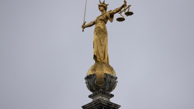 Lady Justice statue atop the Old Bailey in London under clear blue skies, symbolizing fairness and legal authority.