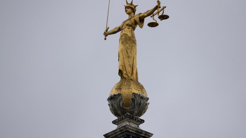 Lady Justice statue atop the Old Bailey in London under clear blue skies, symbolizing fairness and legal authority.