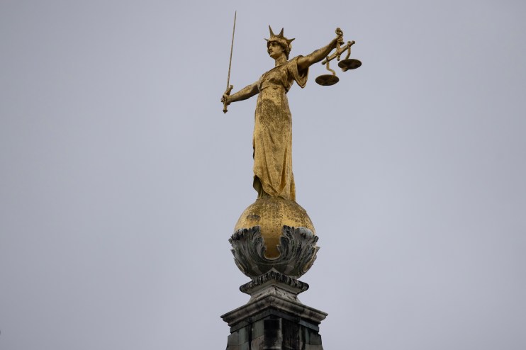 Lady Justice statue atop the Old Bailey in London under clear blue skies, symbolizing fairness and legal authority.