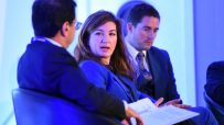 Karren Brady speaking at a business conference, dressed in professional attire, engaging with an audience on stage