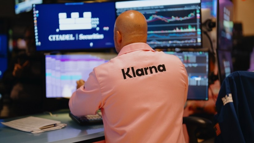 Klarna IPO trading buzz with stock charts and investors analyzing market trends in a professional setting