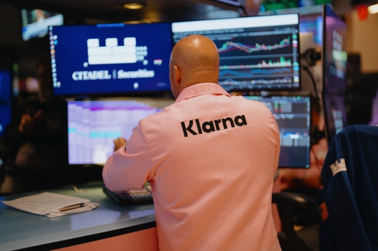 Klarna IPO trading buzz with stock charts and investors analyzing market trends in a professional setting