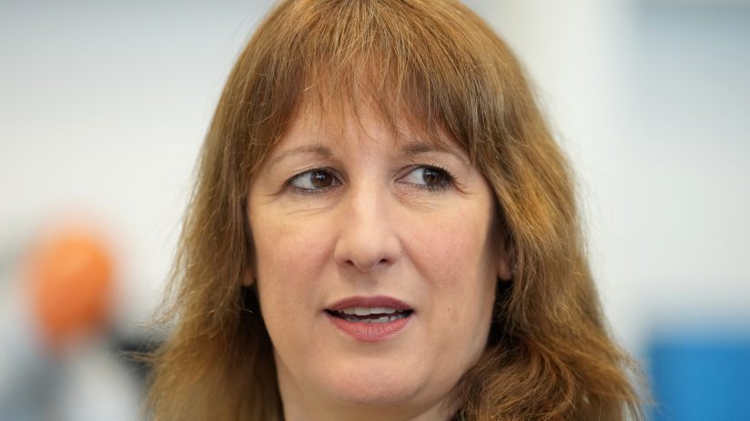 Rachel Reeves in a business suit speaking at a conference podium, addressing economic policies and business strategies