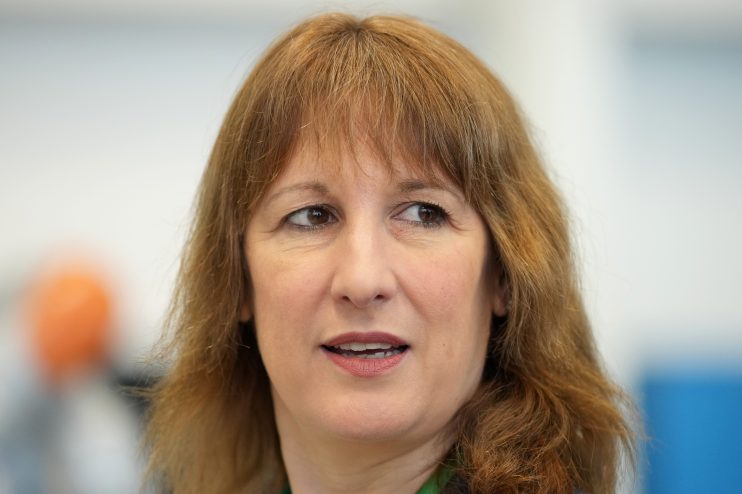 Rachel Reeves in a business suit speaking at a conference podium, addressing economic policies and business strategies