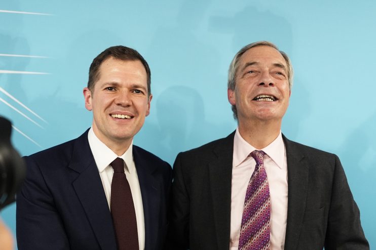 Robert Jenrick and Nigel Farage engage in discussion at a public event, highlighting political dialogue and collaboration.